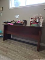 Front view of the brown laminate desk with items on top