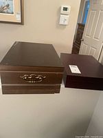 Two closed wooden flatware chests