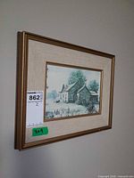 Framed winter homestead print on wall