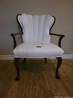 Front view of channel-back cream upholstered armchair