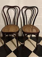 Front view of both bentwood chairs showing curved backs and cane seats
