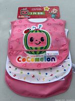Front view of 3-pack Cocomelon bibs in packaging