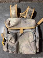 Front view showing camouflage fabric, front zip pocket, magnetic flap, side pockets