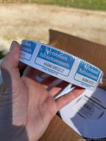 Hand holding shrink-wrapped blue refreshment ticket roll