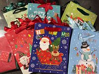 Assorted Christmas gift bags stacked, showing multiple designs