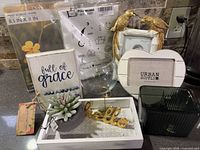 Group shot of all decor items including frames, vases, tray, figurines, sign, succulent, pillowcase