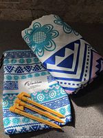 Blanket rolled beside pouch and pegs