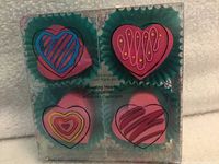 Front of sealed package displaying four pink heart sponges and decorative graphics