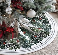 Tree skirt displayed under tree showing design, text and scale
