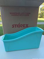 Storex box with one turquoise plastic magazine/book organizer displayed
