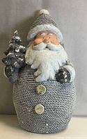 Front view of Santa statue holding tree