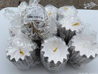 Bundles of pleated wax melt liners in plastic wrap