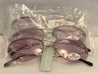Three packaged pairs of sunglasses showing lens tint and tags