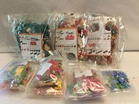 Front view of seven sealed polybags containing assorted micro bricks with instruction sheets