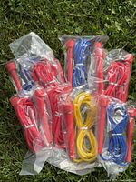 Eight packaged skipping ropes laid out on grass