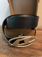Belt rolled with buckle visible in box