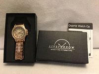 Watch displayed in open box next to closed box