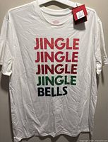 Front view of white holiday slogan T-shirt on hanger showing graphic and overall condition