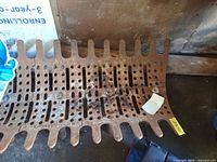 Top view of perforated cast iron grate plate showing rust and overall design
