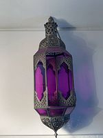 Full view of lantern hanging, showing purple glass and metal frame