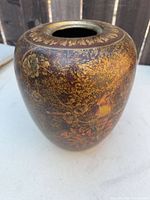 Full view of vase showing gold and brown lacquer with bird and floral motif