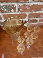 ice bucket, tongs and seven glasses grouped on wood surface