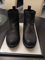 Front view showing both black slip-on boots