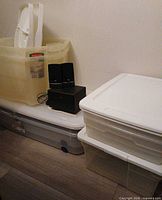 Multiple Rubbermaid clear bins with white lids, speakers not included