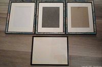 Front view of three blue patterned frames with mats and one black frame without mat