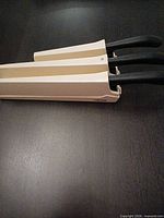 side view of block with three knives inserted