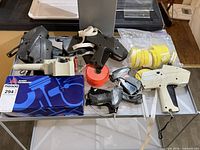 Overall lot with guns, label rolls, fasteners visible