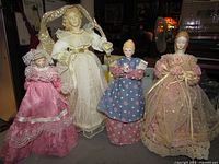 Group of four porcelain-headed tree topper dolls