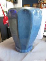 Front view of blue glazed terracotta pot showing faceted panel design and glossy finish