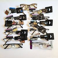 All 13 pairs of reading glasses laid out, tags visible