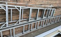 Both aluminum ladders laid flat showing full length and rung structure
