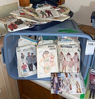 Overview of blue tote bin filled with assorted Simplicity, McCall’s, Butterick and Kwik Sew pattern envelopes