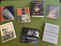 Seven art-related books arranged on table