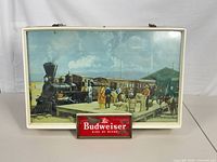 Front view of fluorescent sign showing train scene and Budweiser logo