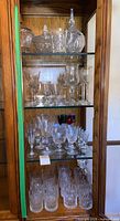Full cabinet view showing crystal stemware, tumblers and serveware