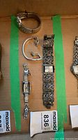 Overview of all four silver tone items inside green-taped section