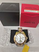 Watch on foam insert with black inner box and red outer box visible