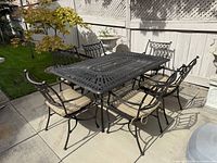 Full view of table with six chairs and cushions
