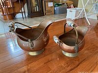 Both copper coal scuttles side by side showing size difference and overall condition