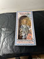 Front view of Vanessa porcelain doll in original window box