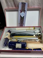 Open box showing assorted taper, pillar candles and incense