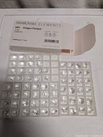 Closed Swarovski Elements box and two trays of crystal octagon pendants
