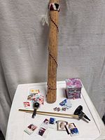 Overview of rain stick standing, stamps scattered, brass gauge parts and mini chest
