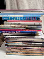 Stack of assorted art and home improvement books, showing many spines