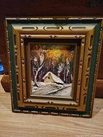 Full view of framed painting showing cottage and frame