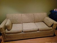 Three-cushion beige sofa bed with arm pillows